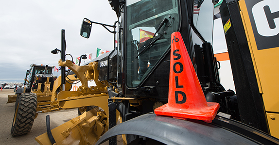 A Caterpillar motor grader is sold at a Ritchie Bros. equipment auction.