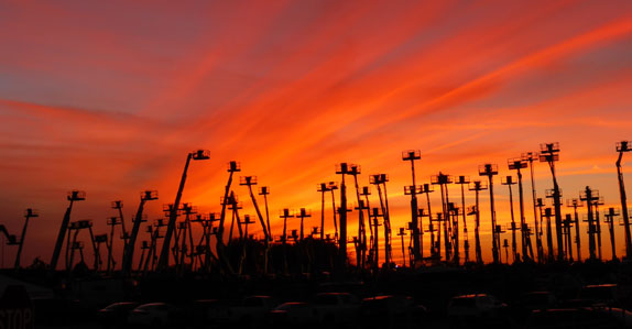 Sunset behind man lifts at Ritchie Bros.' Orlando auction site