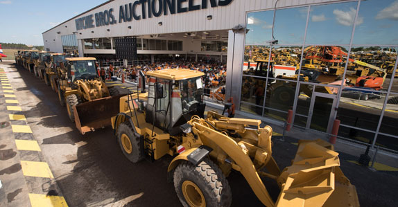 Wheel loaders crossing the auction ramp at Ritchie Bros.' Orlando auction site